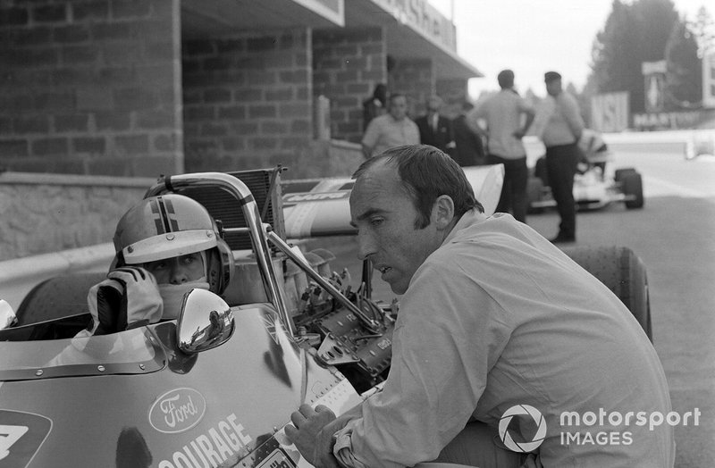 Frank Williams habla con Piers Courage, De Tomaso 308 Ford en el pit lane