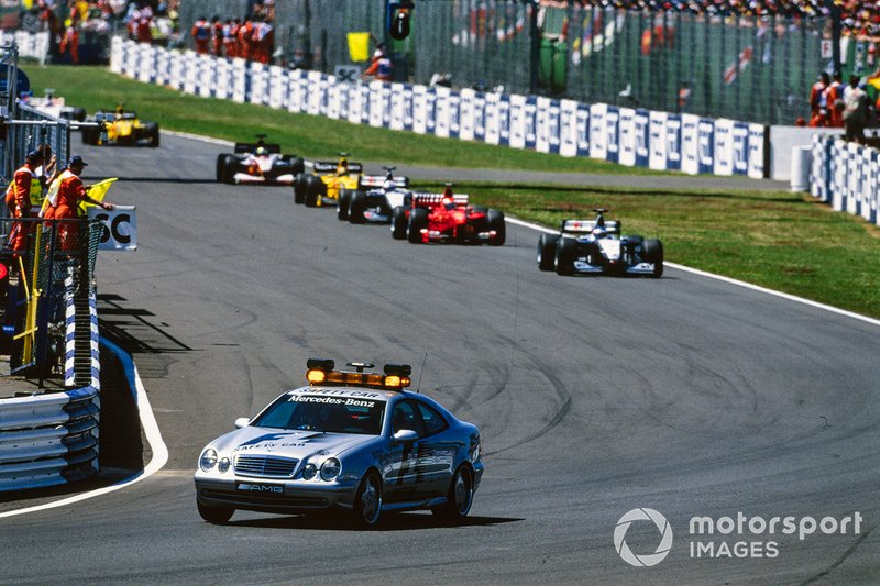 The Safety Car leads Mika Hakkinen, McLaren MP4-14 Mercedes, Eddie Irvine, Ferrari F399, David Coulthard, McLaren MP4-14 Mercedes, Heinz-Harald Frentzen, Jordan 199 Mugen-Honda, Ralf Schumacher, Williams FW21 Supertec, and Damon Hill, Jordan 199 Mugen-Honda