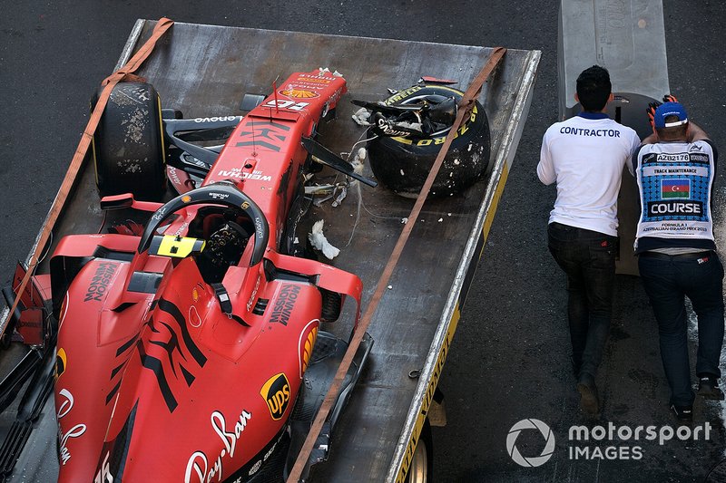 Los oficiales retiran el coche accidentado de Charles Leclerc, Ferrari SF90