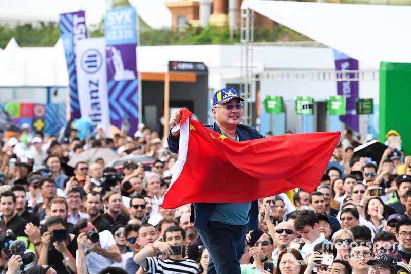 A DS TECHEETAH representative on the podium with a flag of the People's Republic of China