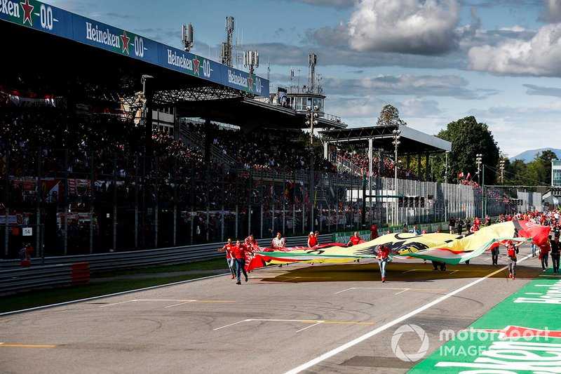 Tifosi storm the track with a Ferrari flag