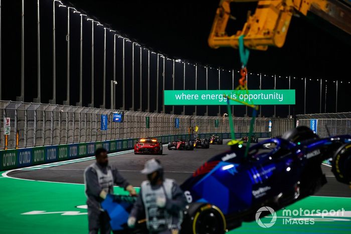 Los oficiales de pista retiran el coche dañado de Nicholas Latifi, Williams FW44, del circuito mientras pasa el Safety Car