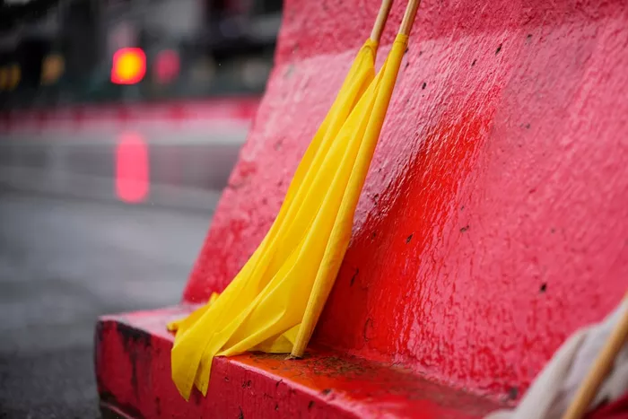 Los comisarios mantienen las banderas amarillas listas para su uso