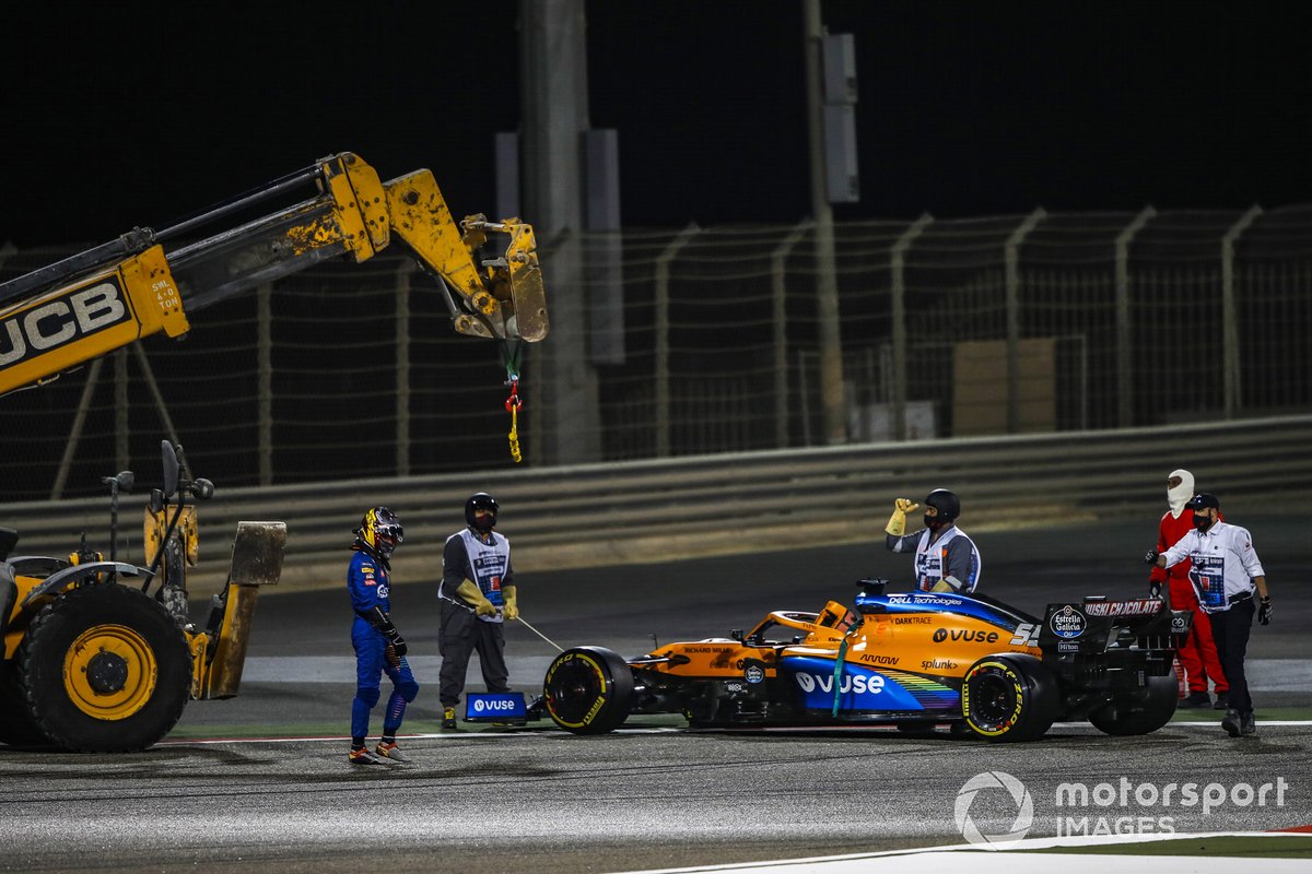 Los oficiales de pista retiran el coche de Carlos Sainz Jr., McLaren MCL35, después de que se detuviera por problemas mecánicos