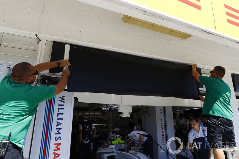 Los trabajadores cambian las placas de nombre de Felipe Massa, Williams, a Paul di Resta