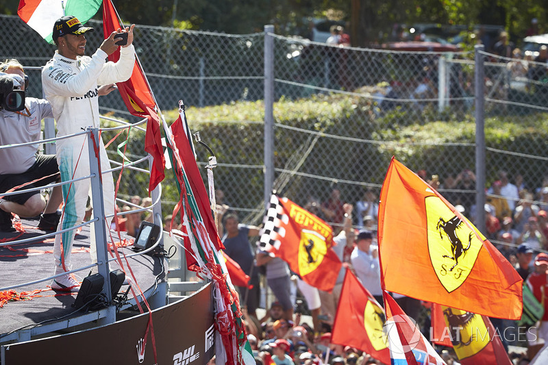 Race winner Lewis Hamilton, Mercedes AMG F1, takes a photo from the podium