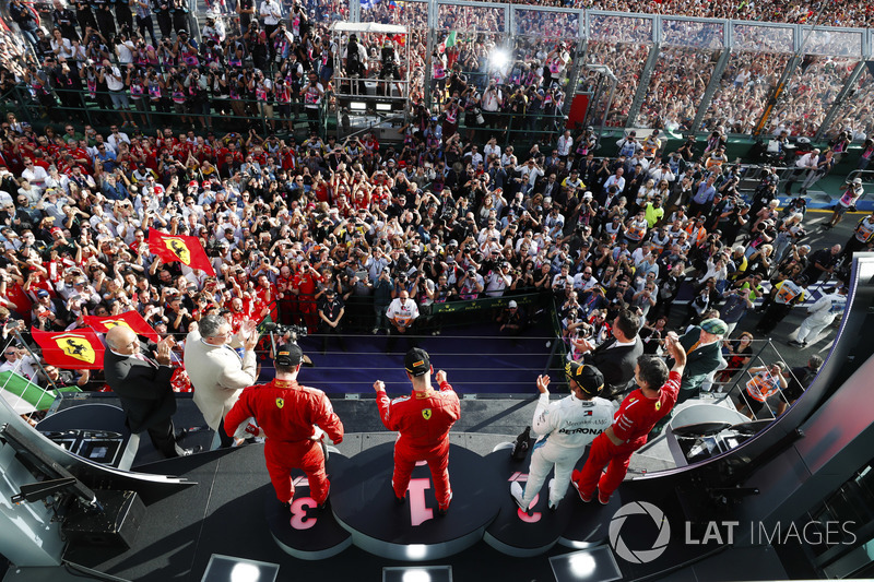 Sebastian Vettel, Ferrari, celebrates victory on the podium with Lewis Hamilton, Mercedes AMG F1, and Kimi Raikkonen, Ferrari