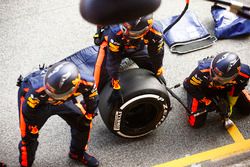 Los mecánicos de Red Bull esperan fuera de su garaje con un neumático Pirelli