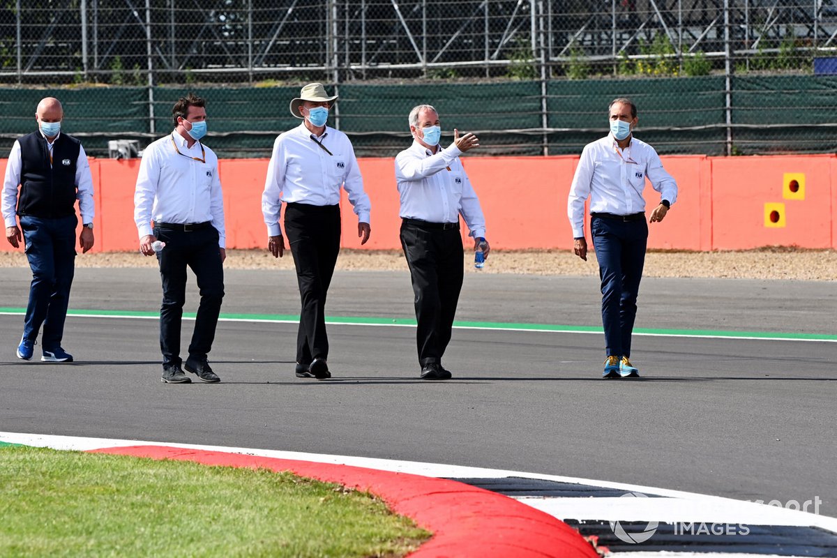 FIA personnel walk the track