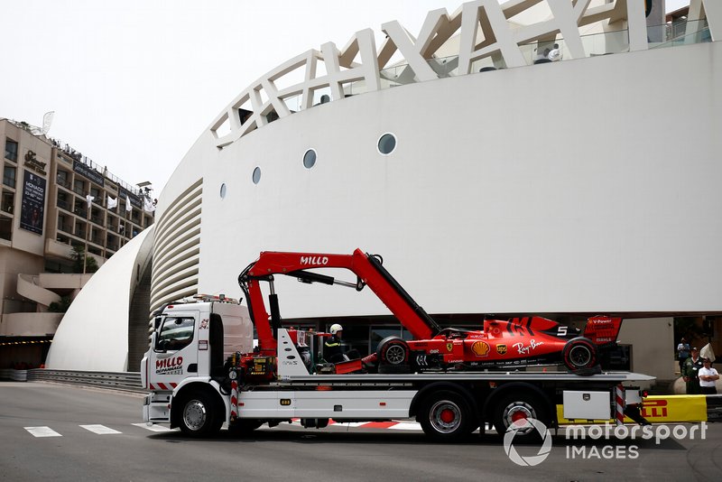 A truck returns the crashed Sebastian Vettel Ferrari SF90 back to the pit lane after FP3