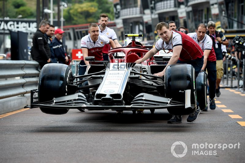 Car of Antonio Giovinazzi, Alfa Romeo Racing C38 bein pushed down the pit lane b Alfa Romeo Racing mechanics