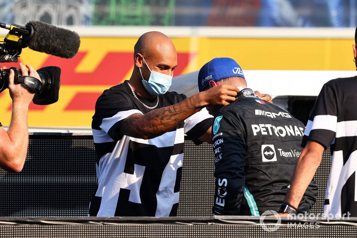 El velocista Lamont Marcel Jacobs entrega a Valtteri Bottas, de Mercedes, 1ª posición, su medalla de vencedor tras la clasificación del sprint