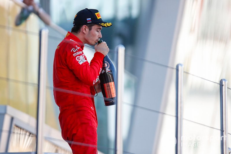 Charles Leclerc, Ferrari, drinks champagne on the podium