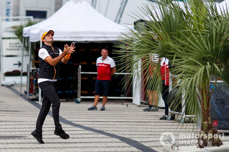 Carlos Sainz Jr., McLaren, catches a rugby ball