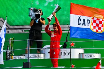 Charles Leclerc, Ferrari, 1st position, lifts the winners trophy