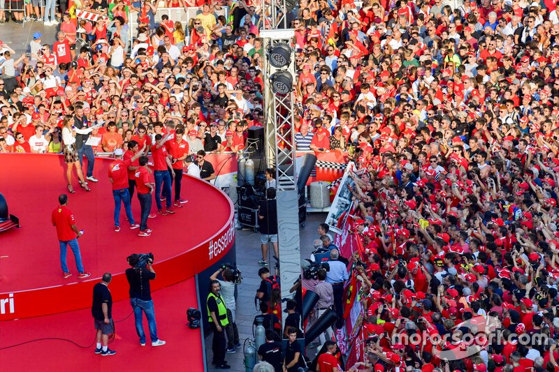 The Ferrari Academy drivers wave to the crowd from the stage