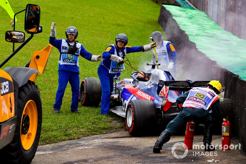 Marshals assist the smoking car of Daniil Kvyat, Toro Rosso STR14, with fire extinguishers