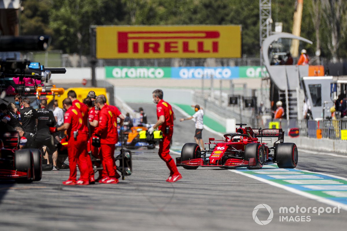 Des mécaniciens devant le garage Ferrari pendant que Charles Leclerc, Ferrari SF21, y rentre