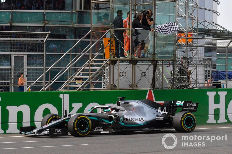 Lewis Hamilton, Mercedes AMG F1 W10, takes the chequered flag