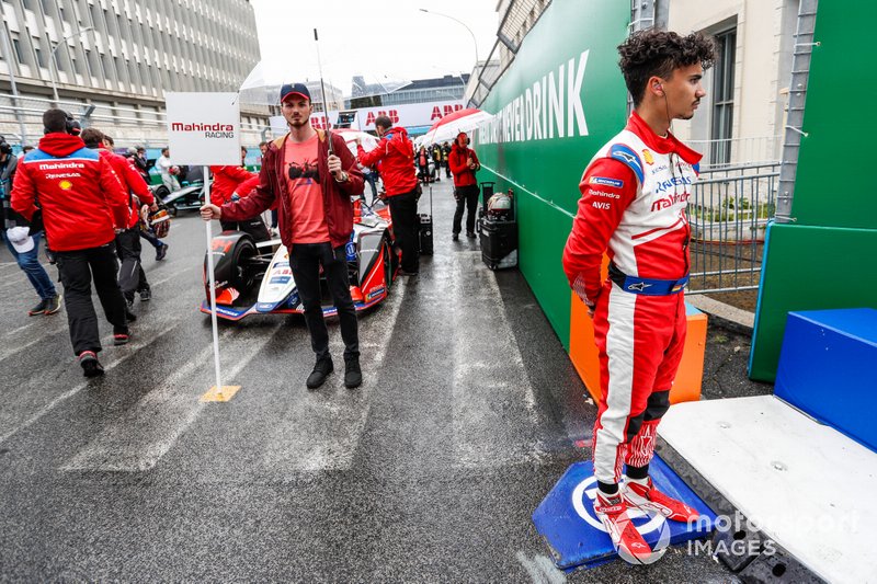 Pascal Wehrlein, Mahindra Racing, stands on a kerb near his M5 Electro which is on the grid