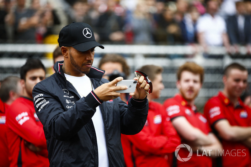 Lewis Hamilton, Mercedes AMG F1, takes a picture of junior garters