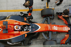 Stoffel Vandoorne, McLaren, is attended to by mechanics in the pit lane