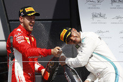 Sebastian Vettel, Ferrari, and Lewis Hamilton, Mercedes AMG F1, celebrate on the podium with champagne