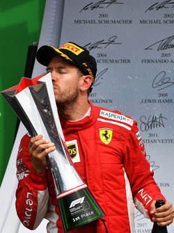 Il vincitore della gara Sebastian Vettel, Ferrari, festeggia sul podio e bacia il trofeo