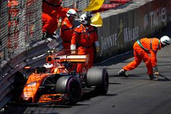 Oficiales de pista limpian los escombros del coche de  Stoffel Vandoorne, McLaren MCL32