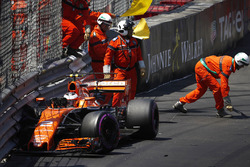 Oficiales de pista limpian los escombros del coche de Stoffel Vandoorne, McLaren MCL32