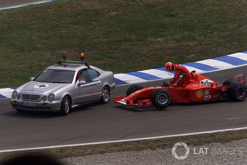 Michael Schumacher, Ferrari F2001, climbs out of his wrecked car