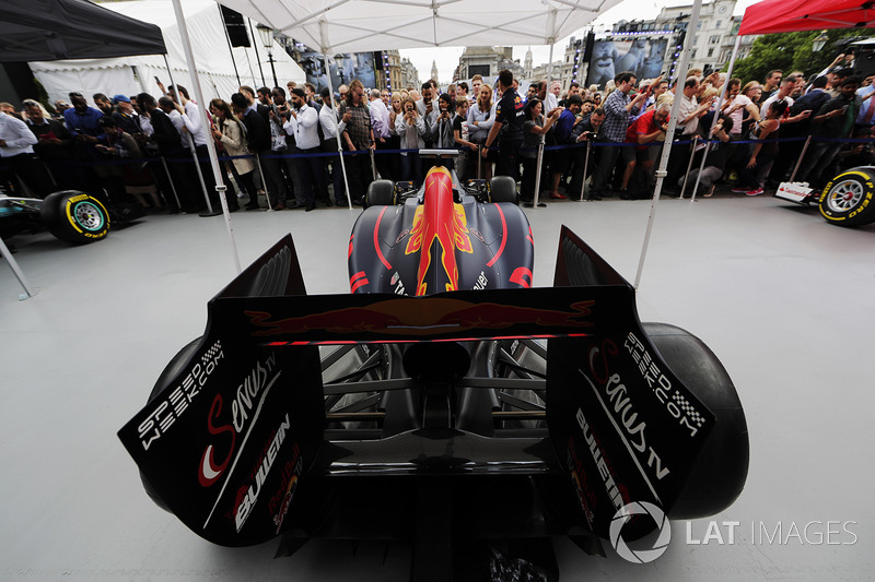 Fans inspect and photograph the Red Bull Racing RB13 on the Red Bull Racing stand