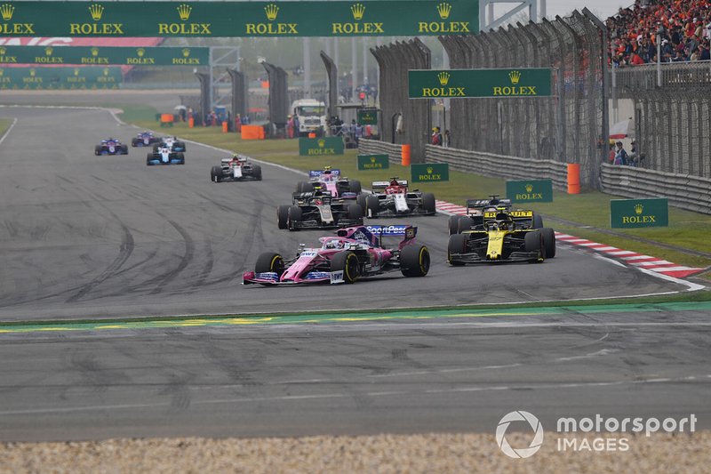 Sergio Perez, Racing Point RP19, leads Nico Hulkenberg, Renault F1 Team R.S. 19, Romain Grosjean, Haas F1 Team VF-19, Kevin Magnussen, Haas F1 Team VF-19, Kimi Raikkonen, Alfa Romeo Racing C38, Lance Stroll, Racing Point RP19, and the remainder of the field on the opening lap