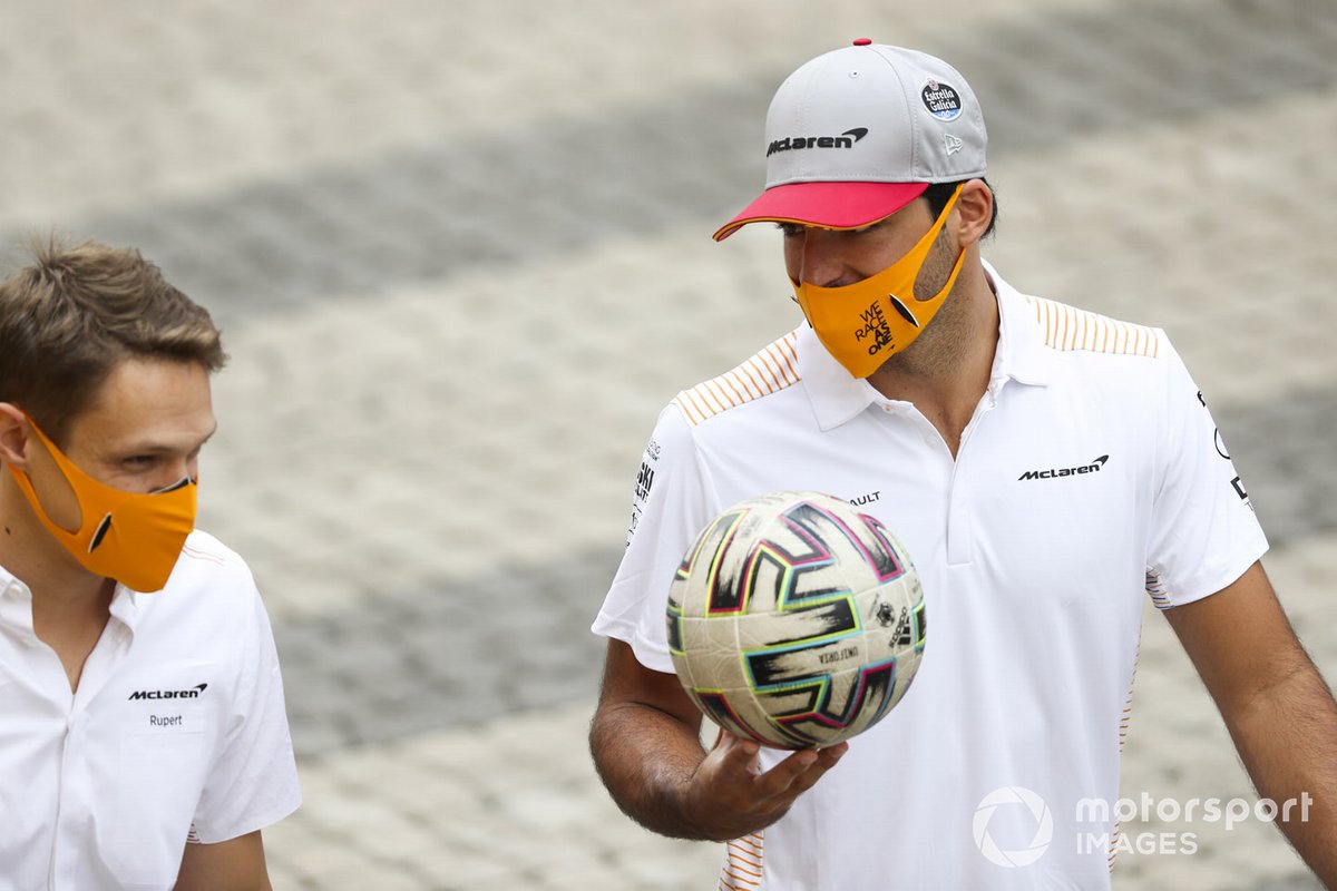 Carlos Sainz Jr., McLaren, llega al paddock con un balón