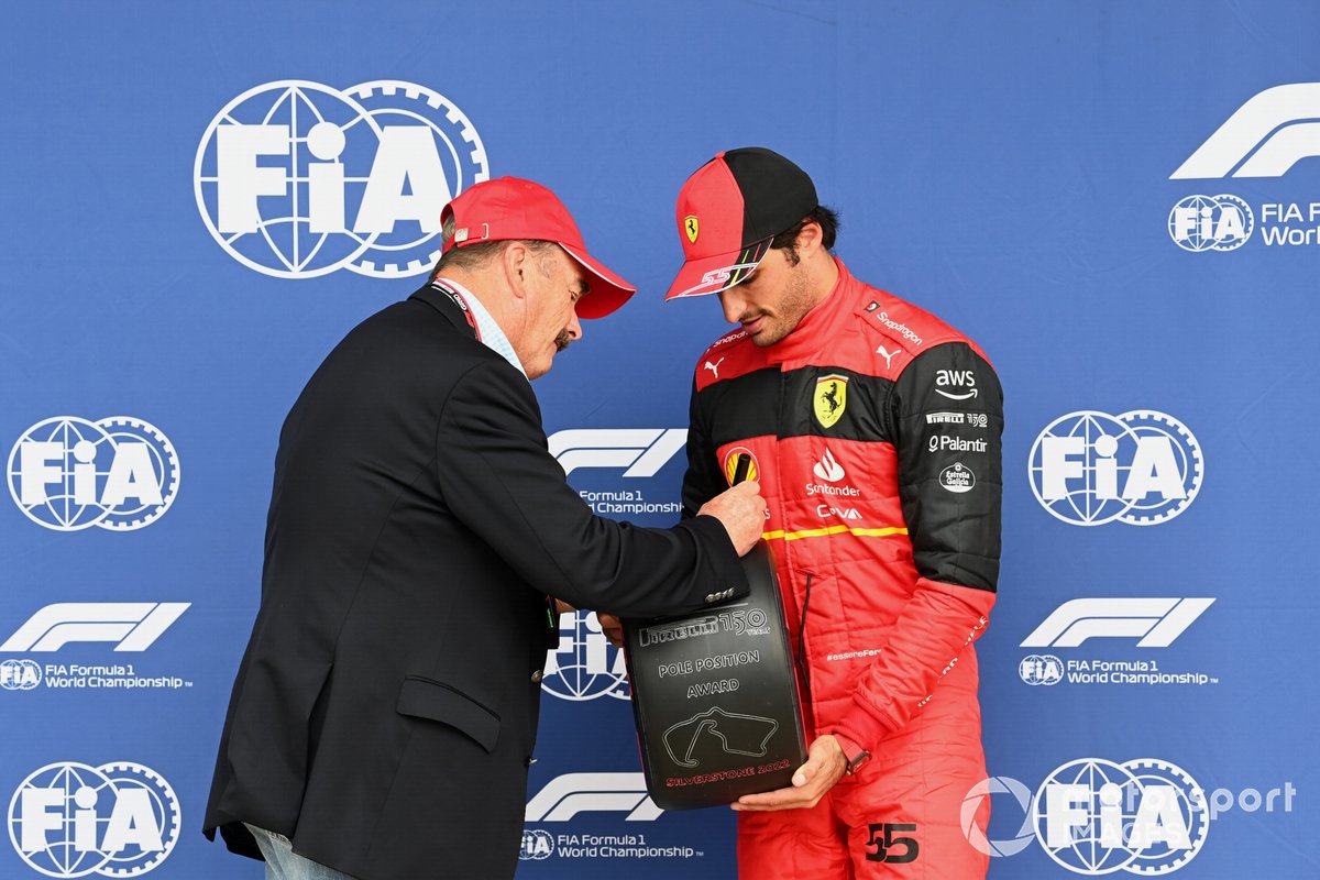 Il campione del mondo 1992 Nigel Mansell firma il premio Pirelli per la pole position prima di consegnarlo a Carlos Sainz, Ferrari.