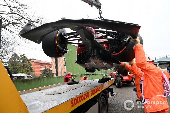 Oficiales de pista cargan el coche de Carlos Sainz Jr., Ferrari F1-75, en una grúa