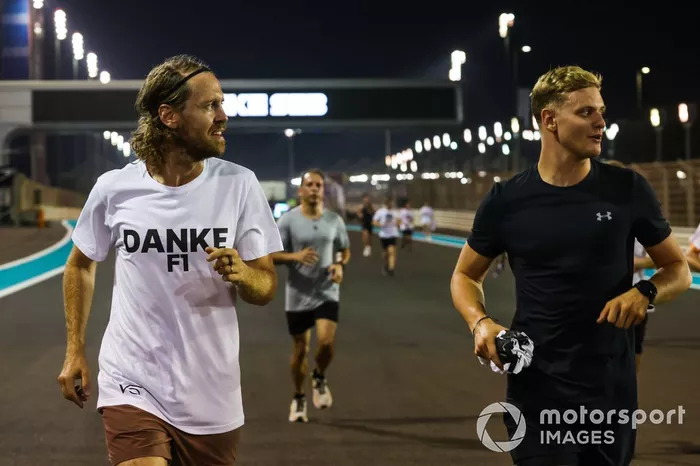 Sebastian Vettel, Aston Martin, es acompañado en una carrera alrededor del circuito por Mick Schumacher, Haas F1 Team, con los buenos deseos como parte de su despedida en su último Gran Premio