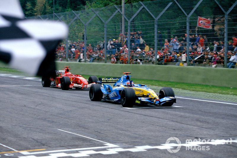 Race winner Fernando Alonso, Renault R25, takes the chequered flag, followed by  Michael Schumacher, Ferrari F2005