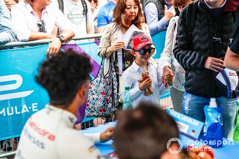 A young fan waits to meet the drivers at the autograph session