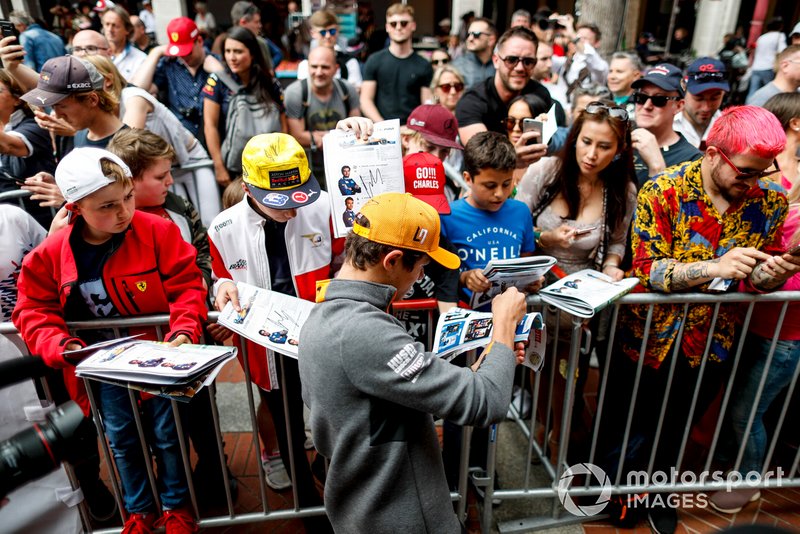 Lando Norris, McLaren signs a autograph for a fan