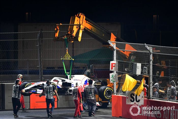 Oficiales de pista retiran el coche dañado de Mick Schumacher, Haas VF-21, del circuito