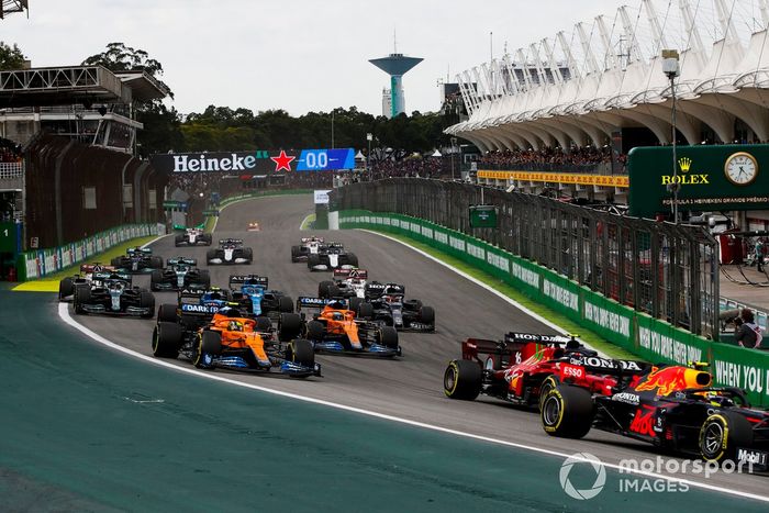 Sergio Pérez, Red Bull Racing RB16B, Charles Leclerc, Ferrari SF21, Pierre Gasly, AlphaTauri AT02, Lando Norris, McLaren MCL35M, Daniel Ricciardo, McLaren MCL35M, y el resto del grupo en la primera vuelta