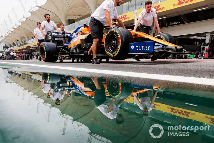 Los mecánicos de McLaren empujan a Carlos Sainz Jr. y McLaren MCL34 por el pit lane