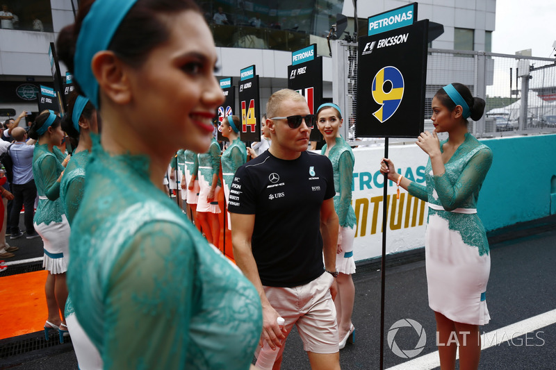 Valtteri Bottas, Mercedes AMG F1, walks through a corridor of grid girls