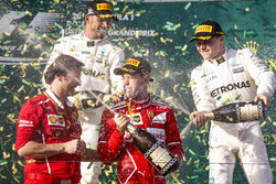 Sebastian Vettel, Ferrari, vainqueur, Lewis Hamilton, Mercedes AMG, deuxième, Valtteri Bottas, Mercedes AMG, troisième, et Luigi Fraboni, chef des opérations piste des unités de puissance Ferrari, sur le podium