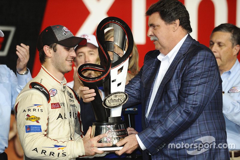 Ganador de la carrera y Campeón 2016 Daniel Suárez, Joe Gibbs Racing Toyota, NASCAR presidente Mike Helton con el trofeo del campeonato de Xfinity Series