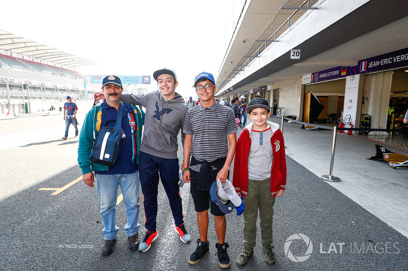 Fans pose for a photo in the pitlane,