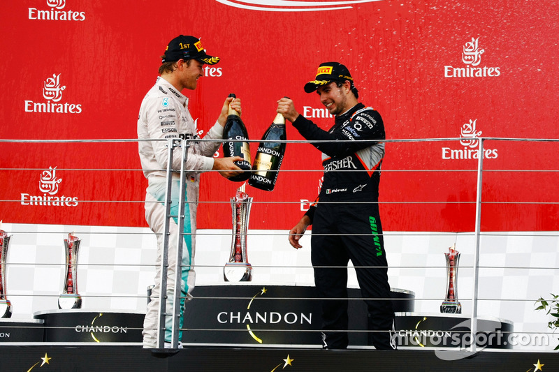 (L to R): Race winner Nico Rosberg, Mercedes AMG F1 celebrates with the champagne on the podium with third placed Sergio Perez, Sahara Force India F1