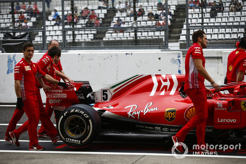 Mekanik Ferrari mendorong mobil Sebastian Vettel, Ferrari SF71H, di pit lane