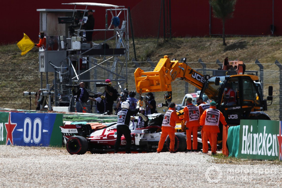 Los oficiales de pista trabajan para recuperar el coche de Kimi Raikkonen, Alfa Romeo Racing C41